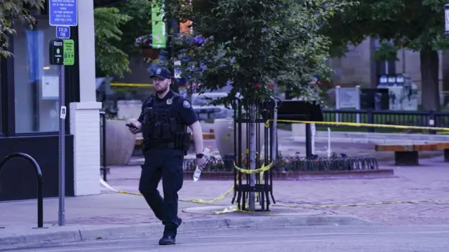 A police officer walks past yellow cordon tape