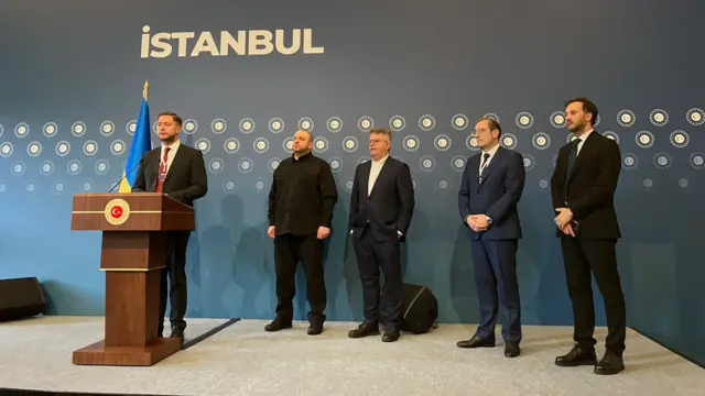 Members of the Ukrainian delegation - including Rustem Umerov, second from left - stand on stage
