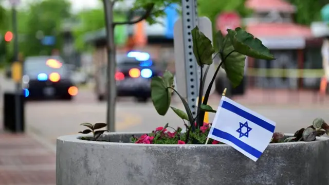 An Israeli flag is placed in front of police tape in a potted plant after the attack in Boulder, Colorado on 1 June 2025.