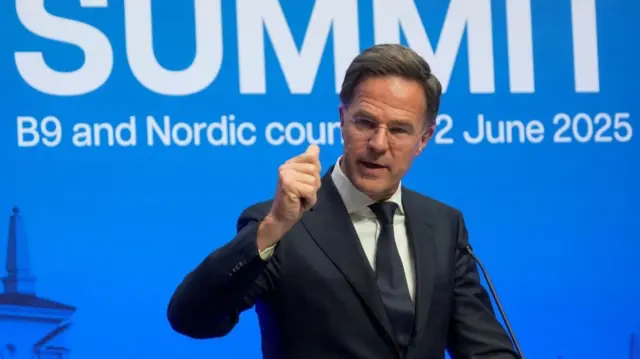 Nato Secretary General Mark Rutte speaking at the summit. He is holding his first up as he talks.