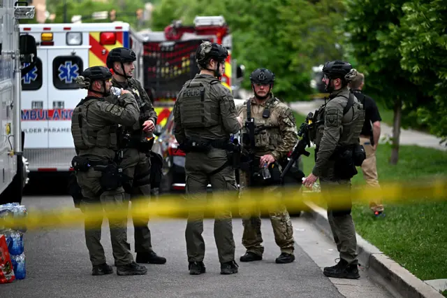Police in military outfits stand clumped together