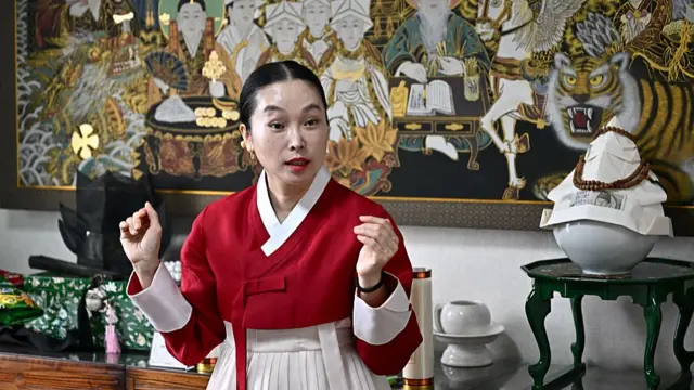 Shaman Yang Su-bong dressed in a red traditional hanbok
