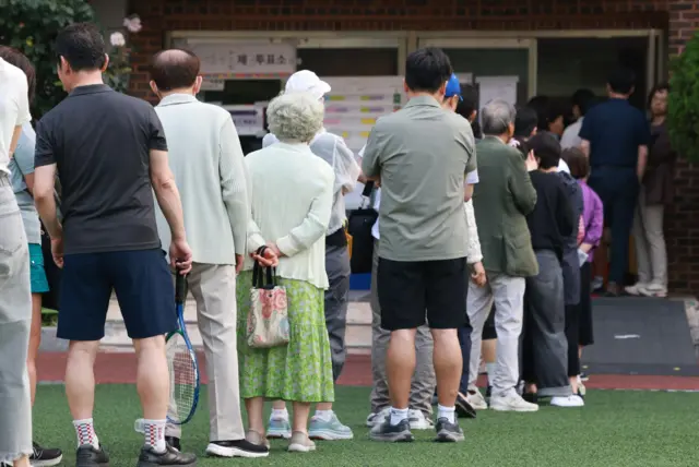 A queue of people wait to cast their ballot in Seoul, South Korea.