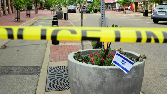 An Israeli flag is placed near police tape, after an attack that injured multiple people, in Boulder