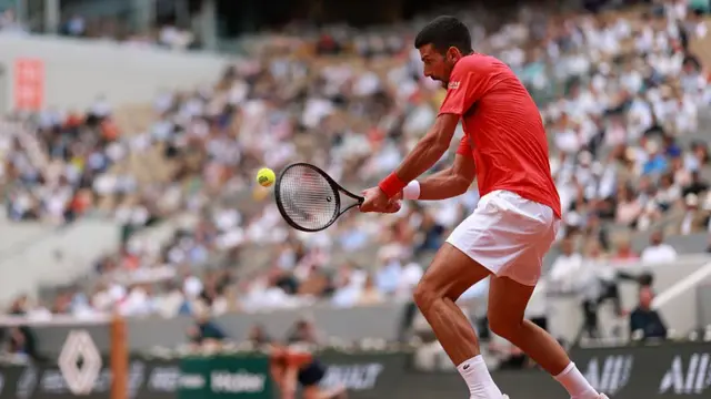 Novak Djokovic plays a backhand