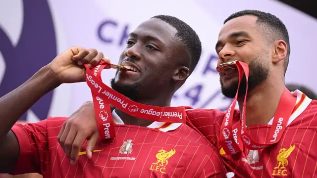 Ibrahima Konate and Cody Gakpo of Liverpool bite their winners medals