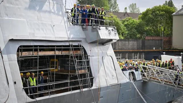 Members of staff watch Prime Minister Sir Keir Starmer during a visit to BAE Systems in Govan, Glasgow