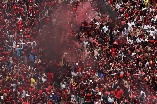 Flamengo fans make noise and let off flares in the stands