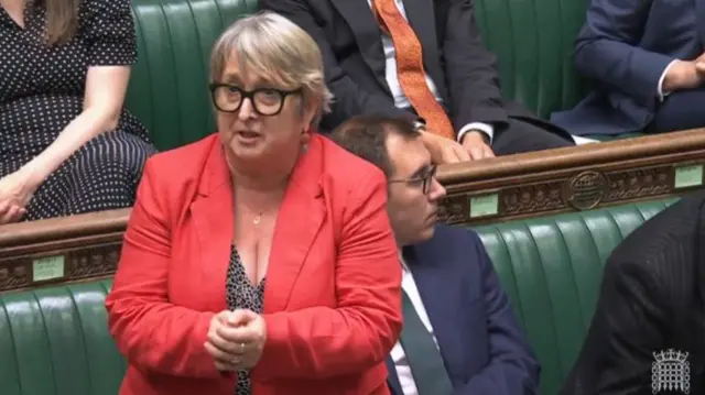 Christine Jardine in red blazer and leopard-print top speaks in the commons