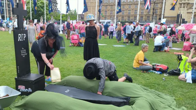 Not Dead Yet campaigners at a mock grave
