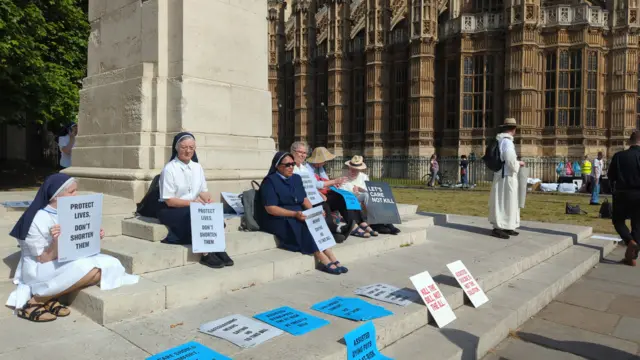 Sisters of Nazereth sit on steps outside Westminster Abbey
