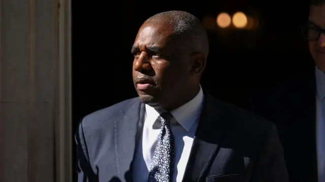 David Lammy walks out of Number 10 wearing a suit.