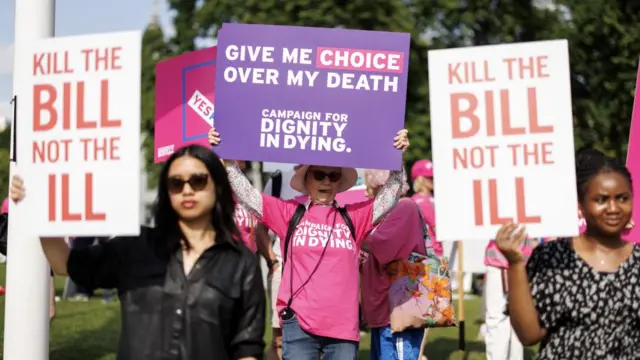 Campaigners and demonstrators in favour and against the assisted dying bill hold placards as they gather in Parliament Square, London, Britain, 13 June 2025