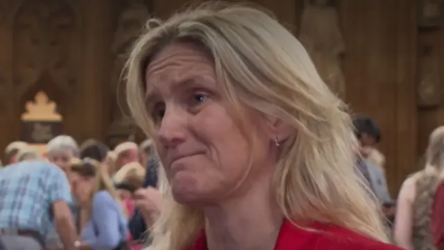 Kim Leadbeater talking. She has long blonde hair and blue eyes. She is wearing a red blazer.