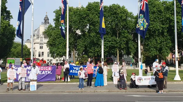 Protesters for and against the assisted dying bill standing in Parliament Square