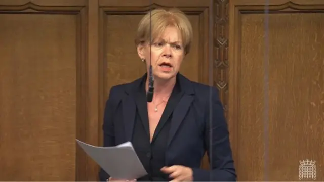 Wendy Morton in black blazer and shirt standing up holding papers in her right hand