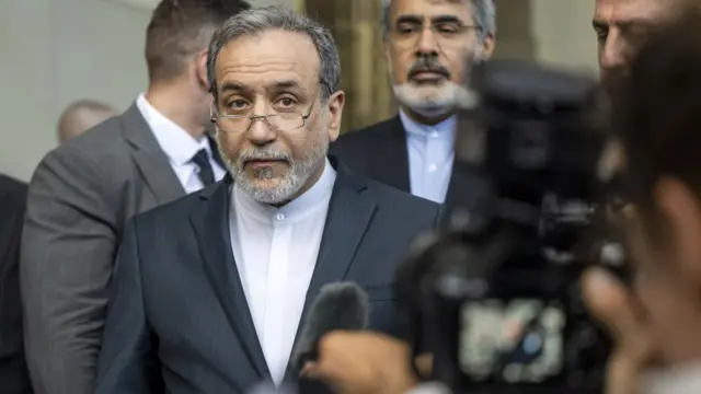 Iran's foreign minister Abbas Araghchi stands in front of a camera.