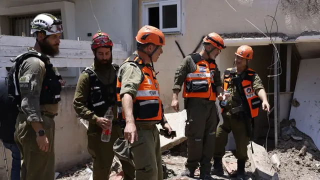 Israeli soldiers and first responders inspect the damage at the site of an Iranian strike in Beit She'an.