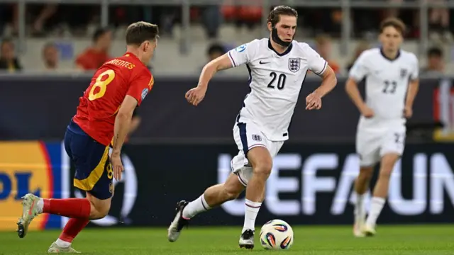 Alex Scott of England runs with the ball whilst under pressure from Benat Turrientes of Spain