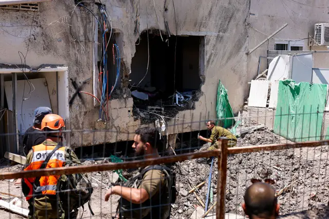 Israeli soldiers and first responders inspect the damage at the site of an Iranian strike in Beit She'an.