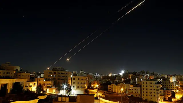 Missiles fired from Iran in retaliation for Israeli attacks are seen in the sky over the Hebron, West Bank