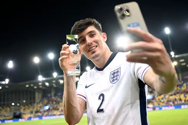 Tino Livramento taking a selfie with the player of the match award