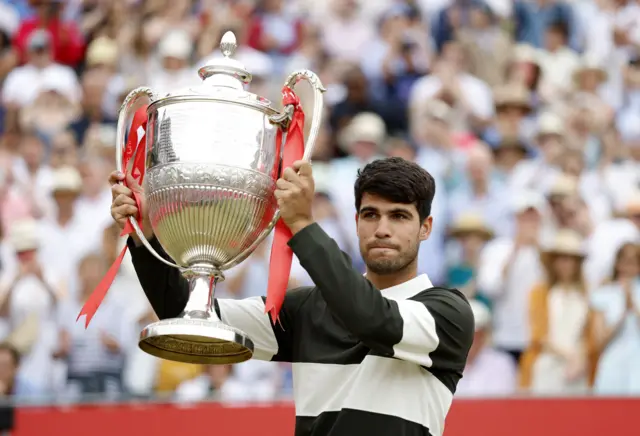 Carlos Alcaraz holds up the Queen's trophy