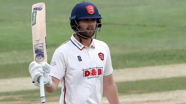 Matt Critchley of Eesex raises his bat to celebrate reaching his fifty