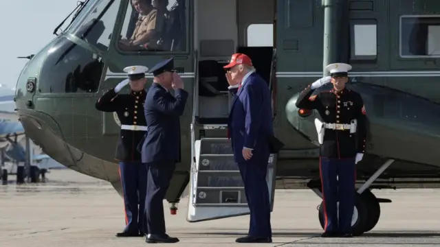 U.S. President Donald Trump salutes Col. Paul R. Pawluk, Vice Commander for the 89th Airlift Wing, before boarding Marine One at Joint Base Andrews