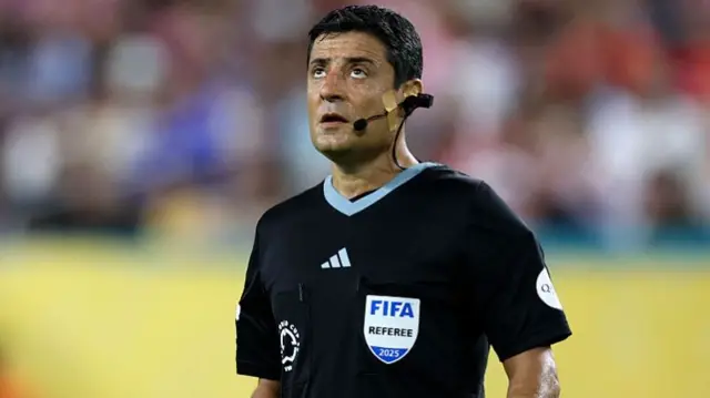 Referee Alireza Faghani looks on as he wears a referee broadcast camera (RefCam)