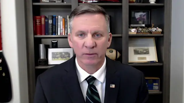 Lt Gen Mark C Schwartz sits in an office with various personal items behind him including an oar.