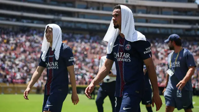 Lee-Kang In and Warren Zaire-Emery of Paris Saint-Germain of PSG cover their heads in a towel due to the heat