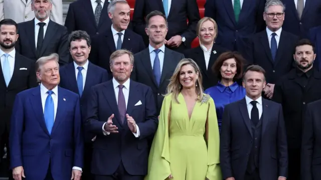 The Dutch King and Queen stand in the centre surrounded by the leaders of Nato countries , as well as the alliance's secretary general and Ukrainian President Volodymyr Zelensky. They are all assembled for a group photo, with most looking into the camera