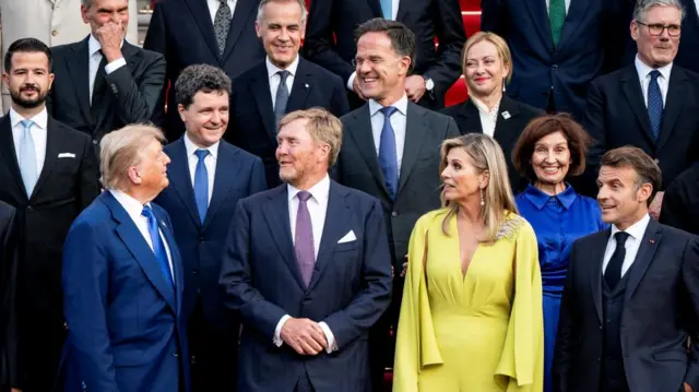 President Donald Trump and and NATO Secretary General Mark Rutte look at each other as they pose for a family photo for the 2025 NATO summit in The Hague, Netherlands,
