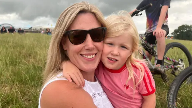 Kate with her daughter Bonnie, sat in a field.