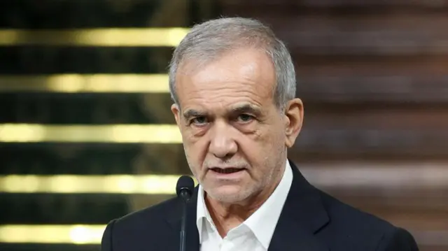 A file photo of Iran's president Masoud Pezeshkian - he is wearing a suit and looking to camera as he speaks into a microphone
