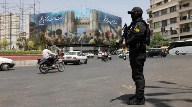 A security guard stands on a street, during early hours of ceasefire, in Tehran, Iran, June 24