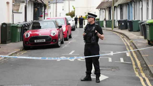 Police officer standing on cordoned off road in Eastbourne