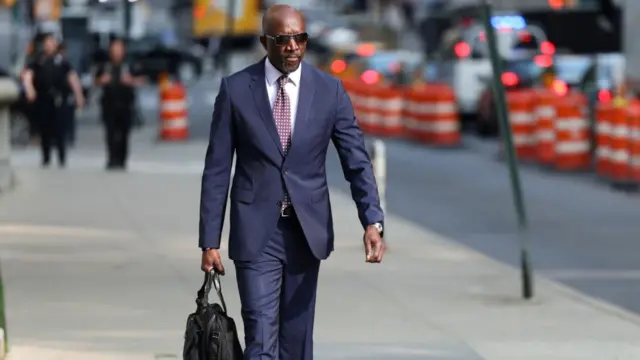 Xavier R. Donaldson, attorney for Sean "Diddy" Combs, arrives at US federal court. he is wearing a dark blue suit over a white shirt and holding a black bag.