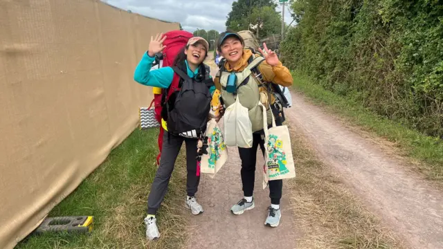 Two women smiling with bags on their backs
