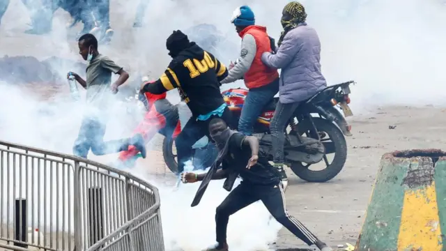 Protester throws back a tear gas to police