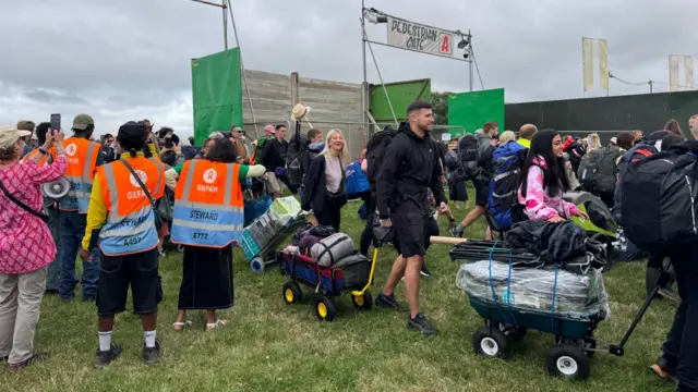 Pedestrian Gate A at Glastonbury Festival. People can been seen walking through and queuing at the gate