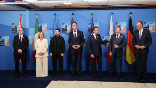 World leaders stand in a row to pose for a photo at a Nato summit in The Hague.