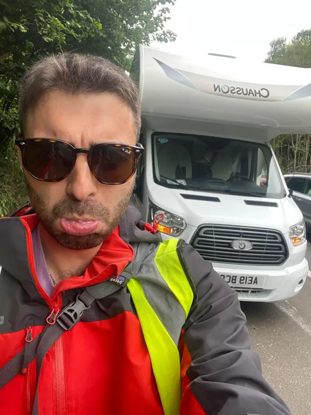 Bobby frowning into camera next to his camper van