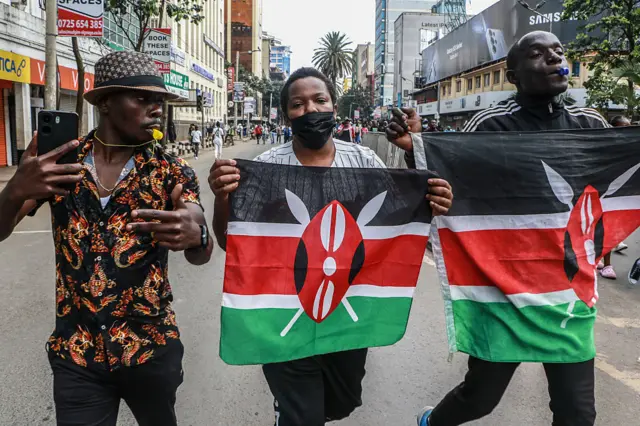 Protesters wave the Kenyan flags while chanting slogans on Moi Avenue during the first anniversary of anti-government demonstrations