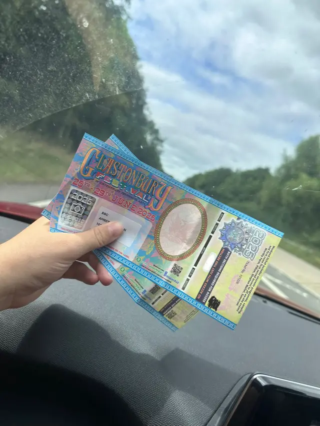 Glastonbury tickets inside a car, with the view looking out of the front window