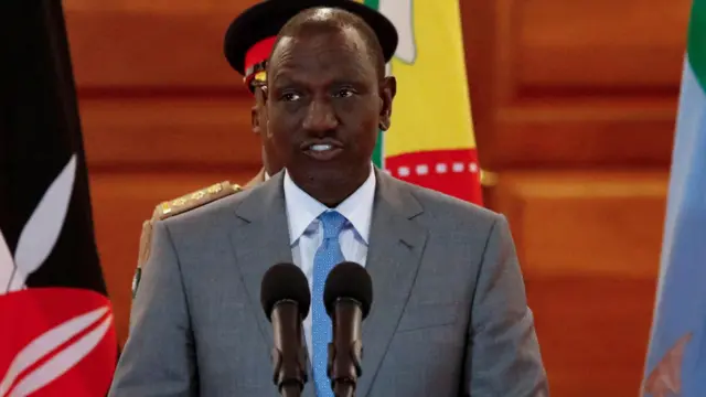 Kenya's President William Ruto in a grey suit, blue tie and white shirt speaks at a press conference in Nairobi