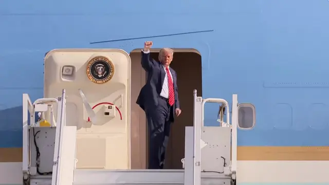 Donald Trump raising a fist as he boards Air Force One
