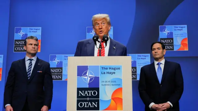Trump stands in the middle, while Hegseth stands to his left and Rubio to his right