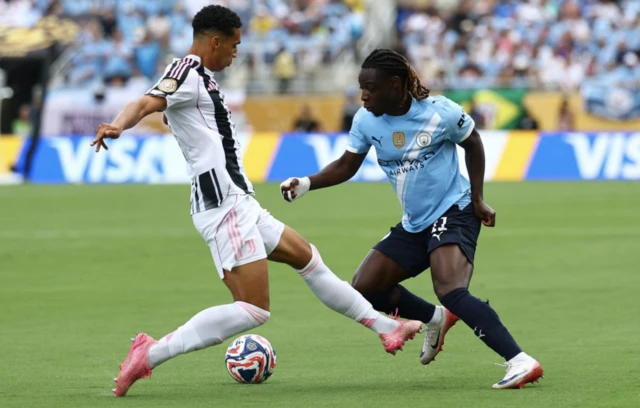 Manchester City's Jeremy Doku in action with Juventus' Alberto Costa